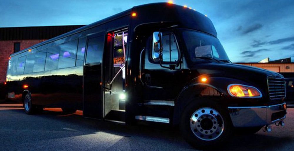 A black bus is parked on the side of the road.